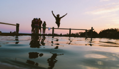 silhouette jumping off dock into water